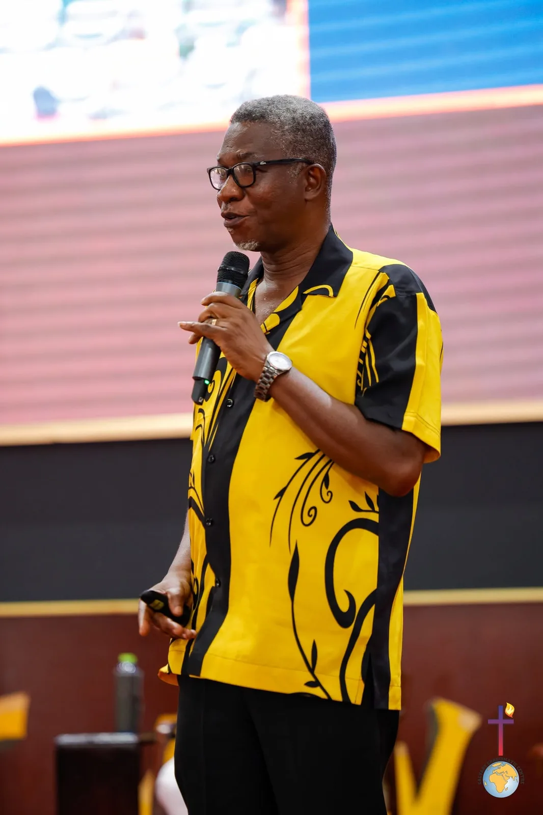 Rev. Vincent Acquaah speaking with a microphone
